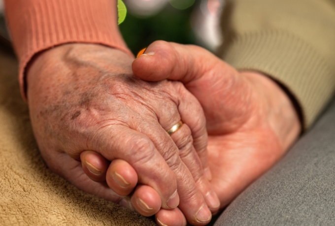Elderly couple holding hands close up tile