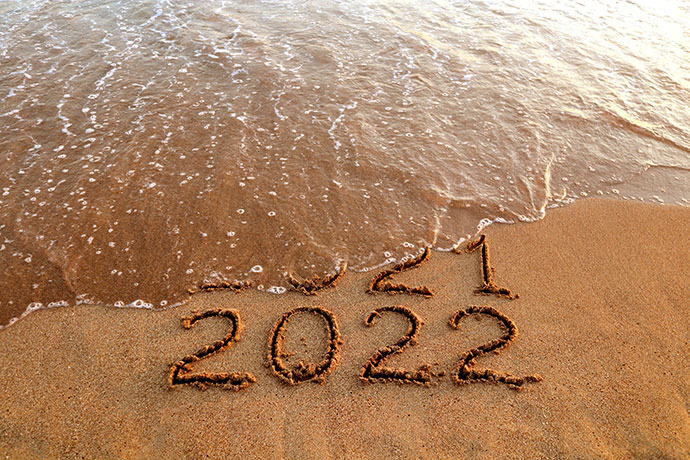 2022 written in the sand on beach with ocean wave