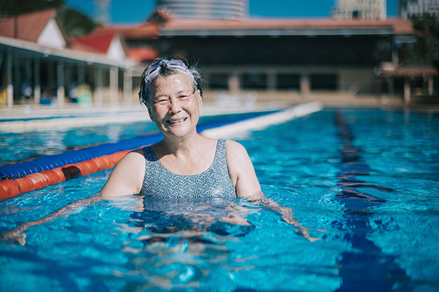smiling older woman in an outdoor public pool