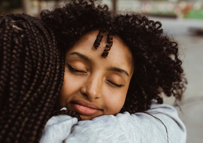 Close up portrait of woman hugging friend