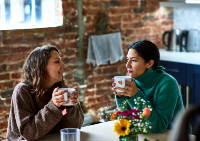 Two women sitting at the table drinking tea