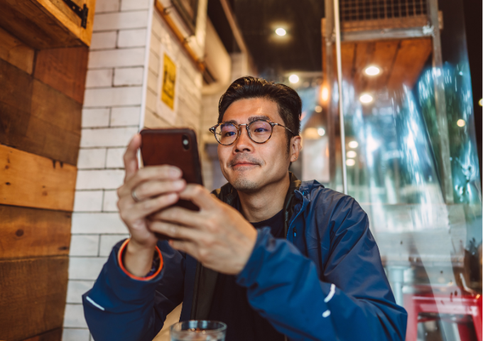 Man sitting in cafe scrolling phone