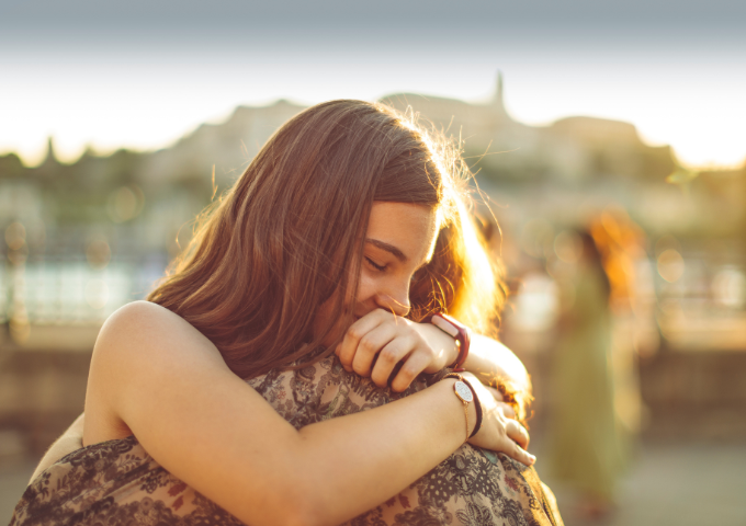 Young girl hugging someone supportively